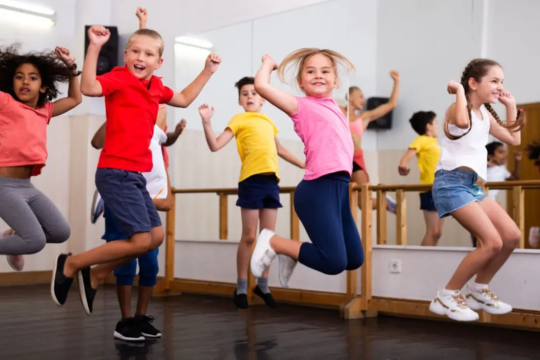 Kinder springen ausgelassen im Tanzraum